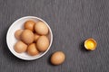 The Eggs in a white plate, one whole egg next to broken egg on the table Royalty Free Stock Photo