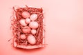 Eggs in a white tray. Creative Easter concept. Modern solid pink background. . Living coral theme - color of the year 2019 Royalty Free Stock Photo