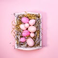 Eggs in a white tray. Creative Easter concept. Modern solid pink