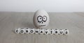 White egg with frightened face on white wooden background