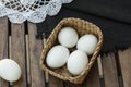 Eggs in a wooden basket which is isolated on wooden table.