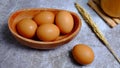 Eggs in a wooden bowl on a table that is neatly and simply arranged which gives an elegant and exclusive impression.