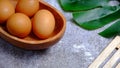 Eggs in a wooden bowl on a table that is neatly and simply arranged which gives an elegant and exclusive impression.