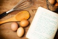 Eggs, wooden spoon and a cook book