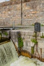 Eglinton Canal Lock with water flowing small waterfalls a metal fence and stone wall