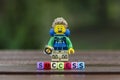 Lego hiker standing behind word success using colorful alphabet beads.