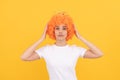 egoistic funny girl with fancy look wearing orange hair wig and princess crown, egoist