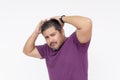 A egotistical man fixes his waxed hair trying to look cool, but looking funny instead. Wearing a purple waffle shirt. Half body Royalty Free Stock Photo