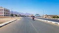 Egypt, Dahab - June 20, 2019: an Arab riding a scooter along one of the streets of Dahab. Desert Street. Egyptian residential