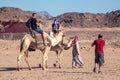Egypt, Hurghada, 12 may 2019, beduins and tourits ride a camels in the desert Royalty Free Stock Photo