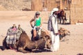 Egypt, Hurghada, 12 may 2019, beduins and tourits ride a camels in the desert Royalty Free Stock Photo