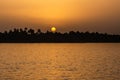 Egypt Nile river view at sunset with tropical palm tree silhouette and distant colorful sun going down Royalty Free Stock Photo