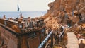 Rocky beach with Arabic cafes in retro style on the red sea coast with umbrellas, sun beds and corals. Egypt