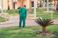 Hotel garden worker spraying lawns