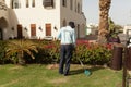 Egypt, Sharm El Sheikh 9 March 2018 Man is cutting trees in the park professional gardener in a uniform cuts bushes Royalty Free Stock Photo