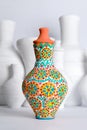 Egyptian decorated colorful pottery vase on background of white vases
