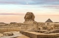 Egyptian Great Sphinx full body portrait with head, feet with all pyramids of Menkaure, Khafre, Khufu in background on a clear, Royalty Free Stock Photo