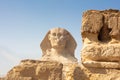 Egyptian Great Sphinx full body portrait with head, feet with all pyramids of Menkaure, Khafre, Khufu in background on a Royalty Free Stock Photo