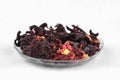 Egyptian hibiscus dry red tea (karkade) on a transparent round plate Royalty Free Stock Photo