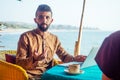 Egyptian man foreign language teacher teaching female student at tropical cafe Royalty Free Stock Photo