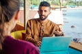 Egyptian man foreign language teacher teaching female student at tropical cafe Royalty Free Stock Photo