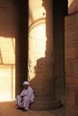 Egyptian man sitting by the column, Philae Temple Royalty Free Stock Photo