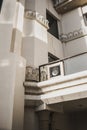 Egyptian patterns on the white wall of the building with a balcony. Sun reflections on the wall