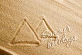 The Egyptian pyramids are painted on the sand and the inscription is summer holidays. Beach background. View from above. The Royalty Free Stock Photo