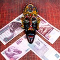 The Egyptian souvenir mask and the Egyptian money, on a red back Royalty Free Stock Photo