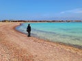 Egyptian woman looking at the turquoise sea in coastal town on the coast of the Sinai Peninsula. Remote