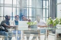 ehind the glass view of executives discussing project in modern office