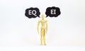 EI Emotional intelligence or EQ emotional quotient symbol. Words EI or EQ. Wooden model of businessman human. Black paper. Royalty Free Stock Photo