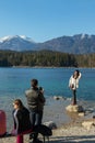 Eibsee, Germany, March 31, 2019: husband taking selfie of his wife for instagram at eibsee