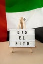 EID EL FITR - Eid Mubarak - Happy Holidays text frame on United Arab Emirates waving flag made from silk material Royalty Free Stock Photo