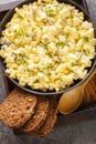 Eiersalat egg salad is a popular German dish that is served on bread closeup on the wooden board. Vertical top view