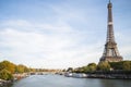 Eifel tower surrounded by the river greenery and a bridge under a cloudy sky in Paris in France Royalty Free Stock Photo