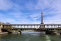 Eiffel Tower against blue sky with clouds and a bridge over Seine River. Paris France. April 2019 Royalty Free Stock Photo