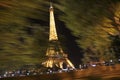 Eiffel Tower in the background in night image with movement of moving lights of traffic in Paris