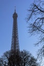 Eiffel Tower behind the trees against the blue sky Royalty Free Stock Photo