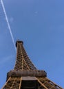 Eiffel Tower from below against the clear blue sky with contrail and airplane Royalty Free Stock Photo
