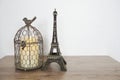 Eiffel Tower And Bird Cage Home Decoration On Wooden Background