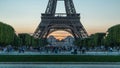 Eiffel Tower day to night timelapse and people sitting on the grass in the evening in Paris, France