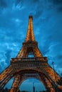 Eiffel tower in Paris against dramatic twilight sky at evening summer time.