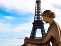 The Eiffel Tower in Paris in the arms of a statue of a seated woman