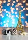 Eiffel Tower toy with Christmas / New Year decorations, ornaments. Blue golden bokeh background. Royalty Free Stock Photo