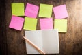 Eight blank colorful sticky notes and notebook and pencil