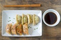 Eight boiled or fried jiaozi or gedza served with soy sauce.