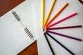 Eight colored pencils lie in a semicircle on white sheets of paper Royalty Free Stock Photo