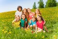 Eight kids sitting together on the green grass Royalty Free Stock Photo