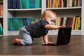 Eight months old todler baby playing with tablet pc on the floor